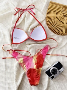 Detailed macro view of tie-dye bikini fabric showing wash label and material texture