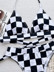 Close-up of black and white checkered bikini set with halter neck ties and cross straps