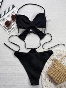 Détail de bikini noir côtelé avec liens croisés au cou et culotte haute échancrée