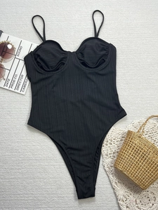 Detailed view of black ribbed one-piece swimsuit with spaghetti straps and ruched bust design