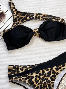 Flat lay of leopard print one-shoulder bikini set with knot detail and accessories
