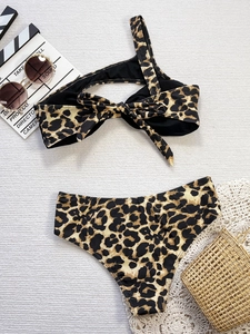 Flat lay of leopard print bikini with one-shoulder bow top and high-waisted bottom