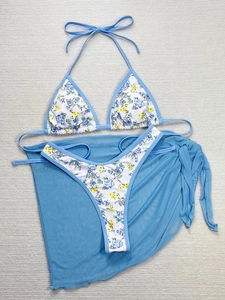 Dettaglio in piano di bikini floreale a tre pezzi con pareo in rete blu cielo