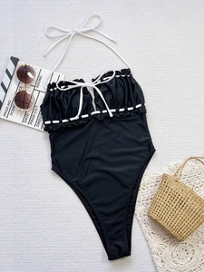 Détails d'un maillot de bain licou noir avec cordon blanc et bordures à volants chic