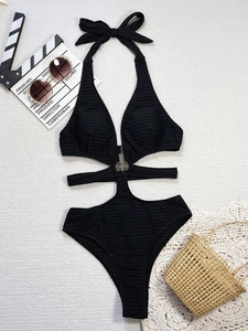 Detail of black ribbed one-piece swimsuit with halter neck and side cut-outs and metal rings