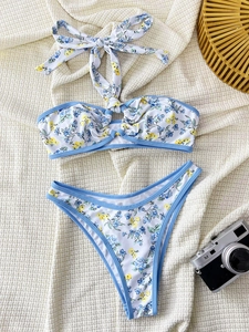 Flat lay of floral bikini with blue trim and high-cut bottoms on white waffle texture