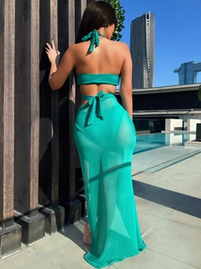 Emerald green hollow bikini set with matching mesh cover-up skirt in poolside setting