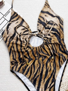 Detail of leopard print halter swimsuit with center cutout and gold-tipped drawstrings