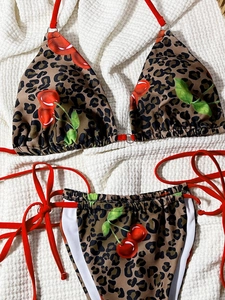 Detail of leopard print bikini with red cherry patterns and side-tie adjustable strings