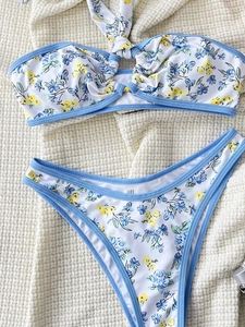 Flat lay of floral bikini set with blue trim and halter neck on waffle texture fabric