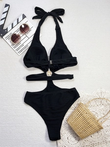 Detail of black cutout monokini with ribbed texture and a gold star-shaped ring ornament