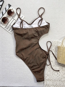 Maillot de bain une pièce marron ajouré avec accessoires de vacances sur tapis blanc