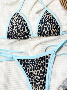 Flat lay of leopard print bikini with light blue contrasting trims on waffle fabric
