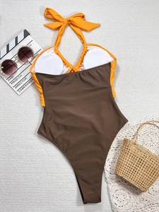Chic orange and brown halter neck bikini set displayed with beach accessories