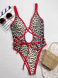One-piece leopard print swimsuit with red contrast straps and waist cut-out detail