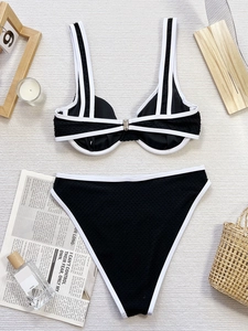 Bikini due pezzi nero con bordo bianco, fibbia frontale e slip a vita alta