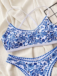 Detailed flat lay of blue floral bikini with scalloped edges on textured background
