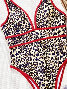 Détail d'un maillot de bain léopard avec col en V profond et rayures rouges décoratives