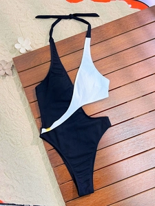 One-piece swimsuit with black and white color blocking, halter ties, and side cut-outs