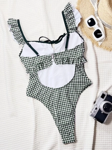 Detail of green gingham swimsuit featuring ruffle trim and open back with metal buckle
