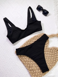 Detailed close-up of a black ribbed two-piece bikini set with textured fabric surface