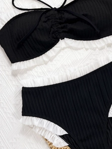 Two-piece black and white bikini set with ribbed texture and ruffled trim edges