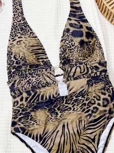 Dettaglio del costume intero leopardato con fibbia di perle e scollo a V profondo