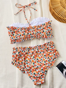 Close-up view of vibrant floral print and elegant ruffle trim on a bandeau bikini set