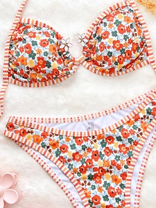 Detailed close-up of floral bikini with striped trim and 3D white flower decoration