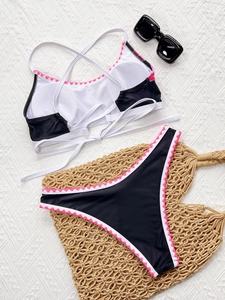 Flat lay of high waist bikini set with pink scalloped trim and stylish black sunglasses