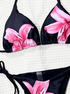 Two-piece bikini set with black floral lily pattern and side-tie triangle bottom