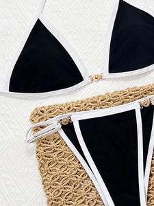 Detail of black and white bikini set with elegant gold metal ring accents and piping