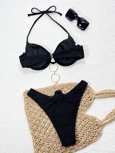 Detail of black ribbed bikini top featuring elegant gold metal link ring hardware