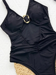 Solid black cutout one-piece swimsuit with gold ring hardware for beach vacation wear