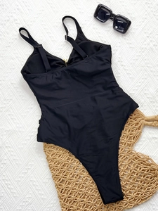 Solid black one-piece swimsuit with cutout detail and metal buckle for beach vacation
