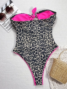 Maillot de bain une pièce imprimé léopard avec nœud rose sur fond de plage