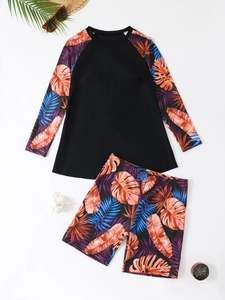 Flat lay of long-sleeve rash guard and boyleg shorts with tropical palm leaf print