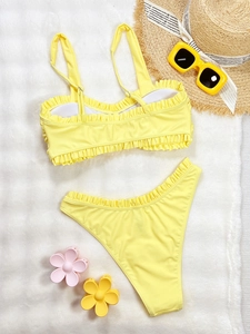 Maillot de bain deux pièces jaune vif avec volants, lunettes et chapeau sur fourrure