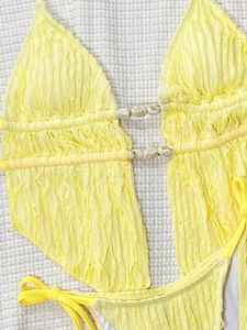 Détails du maillot de bain jaune avec texture froncée, perle marbre et nœuds