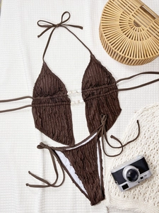 Vue détaillée du bikini à texture gaufrée avec accent de coquillage sur fond blanc