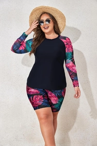 Detail of plus size long sleeve swimsuit featuring vibrant tropical leaf print and navy fabric