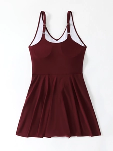 Detail view of burgundy plus size swimsuit with adjustable silver buckles and pleated skirt