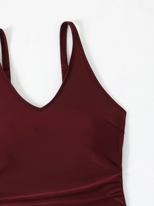 Detail of burgundy V-neck plus size swimsuit featuring side ruching and thin straps