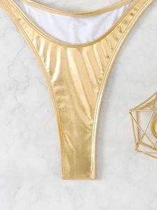 Macro shot of shimmering gold metallic bikini bottom with premium reflective finish