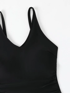 Close-up of black V-neck swimsuit with pleated details and shiny elastic fabric