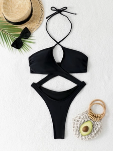 Flat lay of black halter monokini with cut-out details and stylish beach accessories