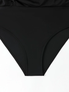 Detailed close-up of double-stitched seams on black plus size one-piece swimsuit fabric