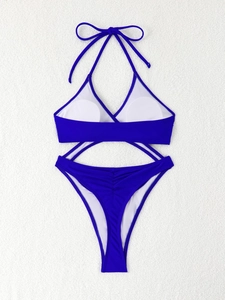 Flat lay of electric blue two-piece swimsuit with halter top and ruched bikini bottom