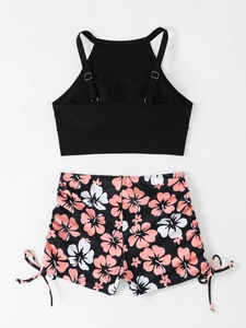 Détails à plat du haut de bikini noir et du short de bain à imprimé floral avec cordons