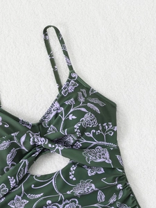 Détail d'un maillot de bain vert foncé avec imprimé fleuri et découpe à nœud frontal
